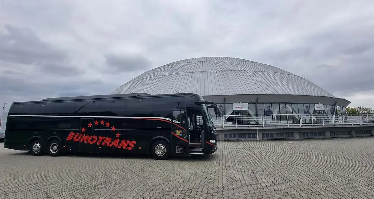 Czarny autokar Eurotrans z czerwonymi gwiazdami i napisem. Zastanawiasz się, ile miejsc ma autokar?