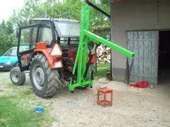 Pomysł na to, jak zrobić ładowacz na tył ciągnika. Zielona konstrukcja zamontowana na traktorze, gotowa do pracy.