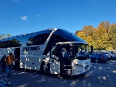 Biały autokar Eurotrans z otwartymi drzwiami, gotowy do podróży. Różnica między autobusem a autokarem jest widoczna w jego przeznaczeniu.