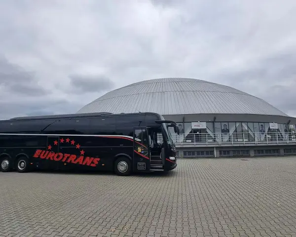 Czarny autokar Eurotrans z czerwonymi gwiazdami i napisem. Zastanawiasz się, ile miejsc ma autokar?