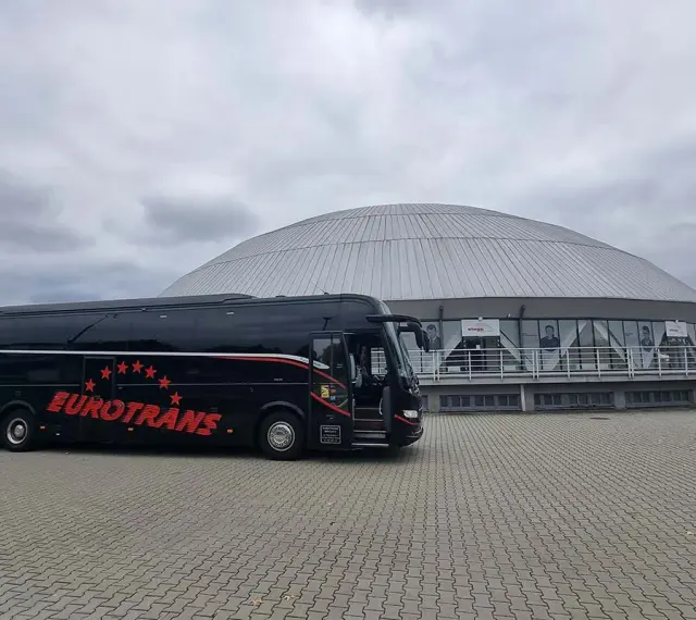 Czarny autokar Eurotrans z czerwonymi gwiazdami i napisem. Zastanawiasz się, ile miejsc ma autokar?
